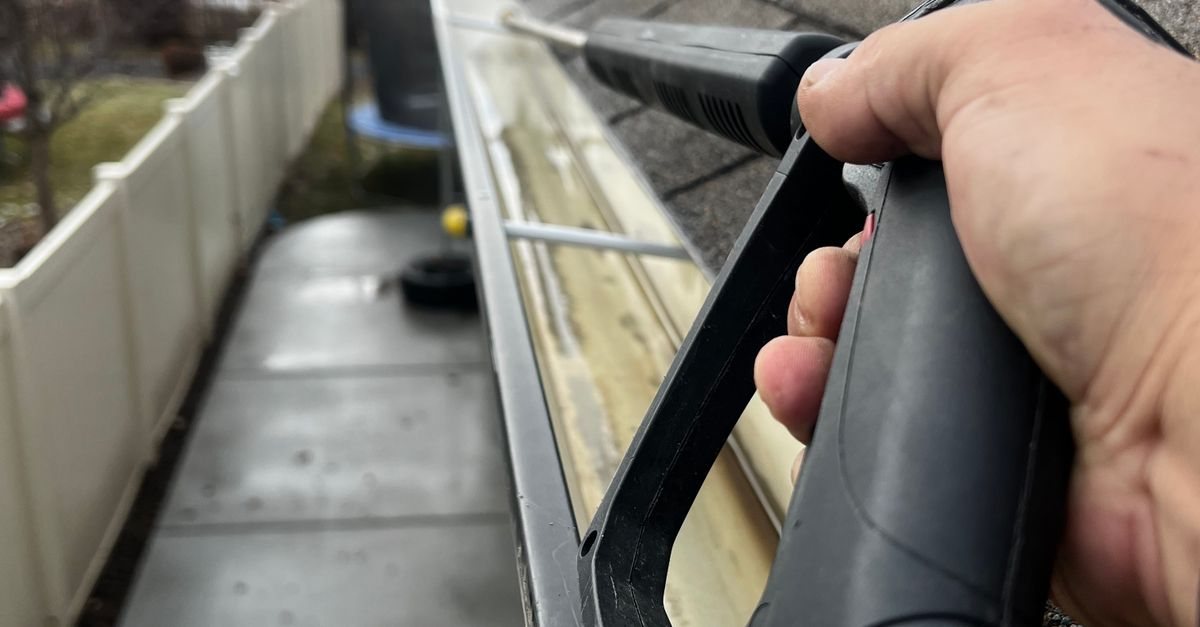 Professional cleaning a residential gutter