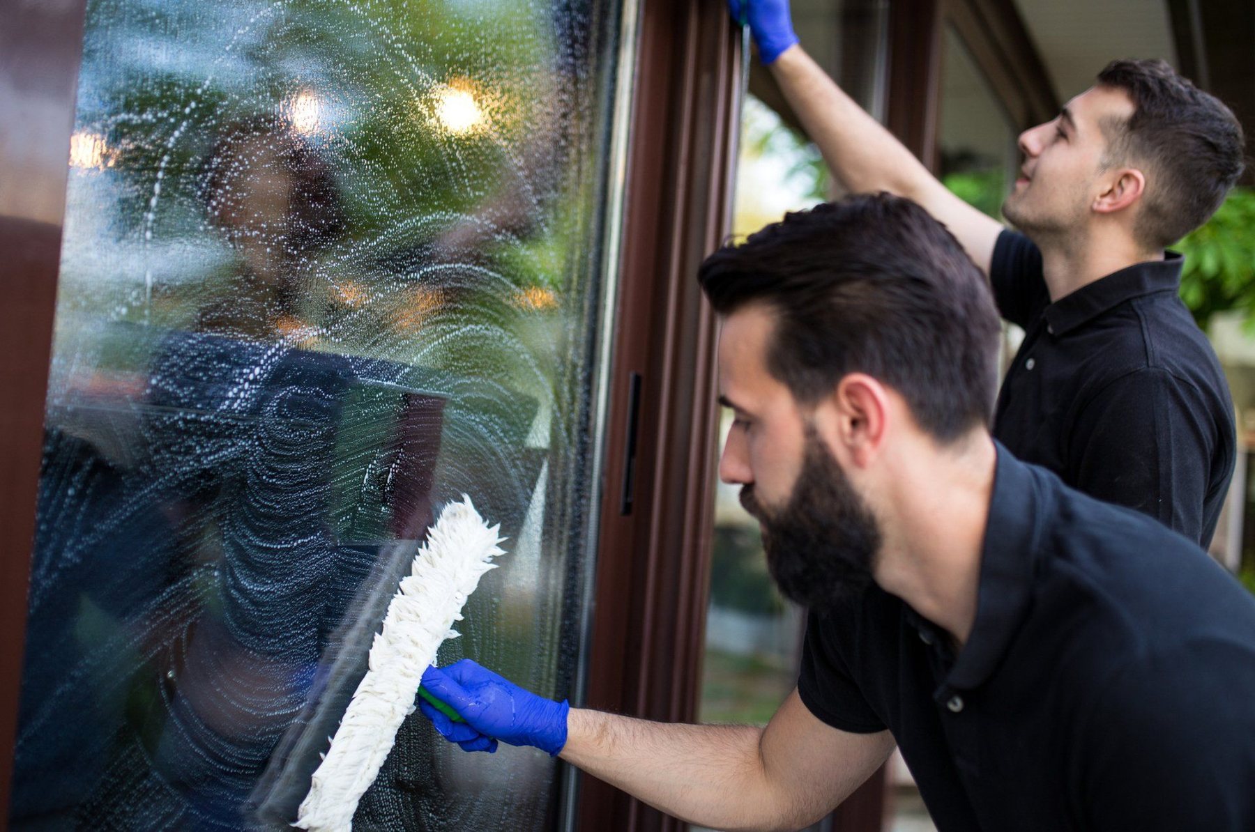 Professional team cleaning the windows of a home
