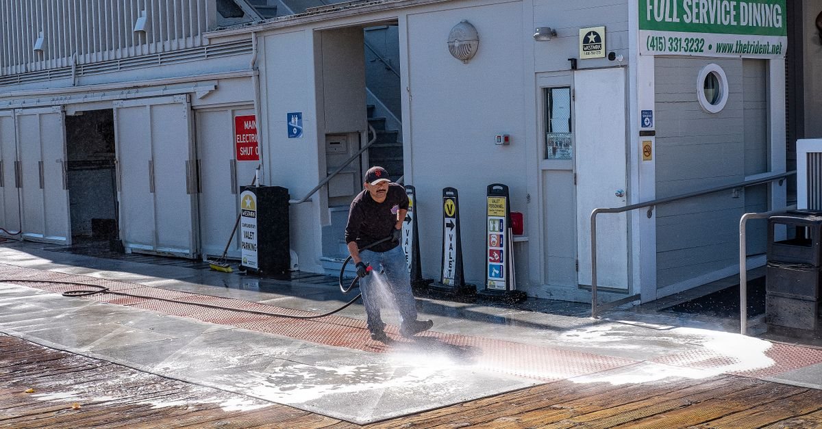 Professional pressure washing an outdoor surface